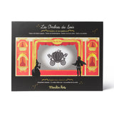 Product packaging for 'Les Ombres du Soir' with a design of a carriage and shadow puppets on a black  Shadow Puppet Theater game film themed toys for kids on white background.