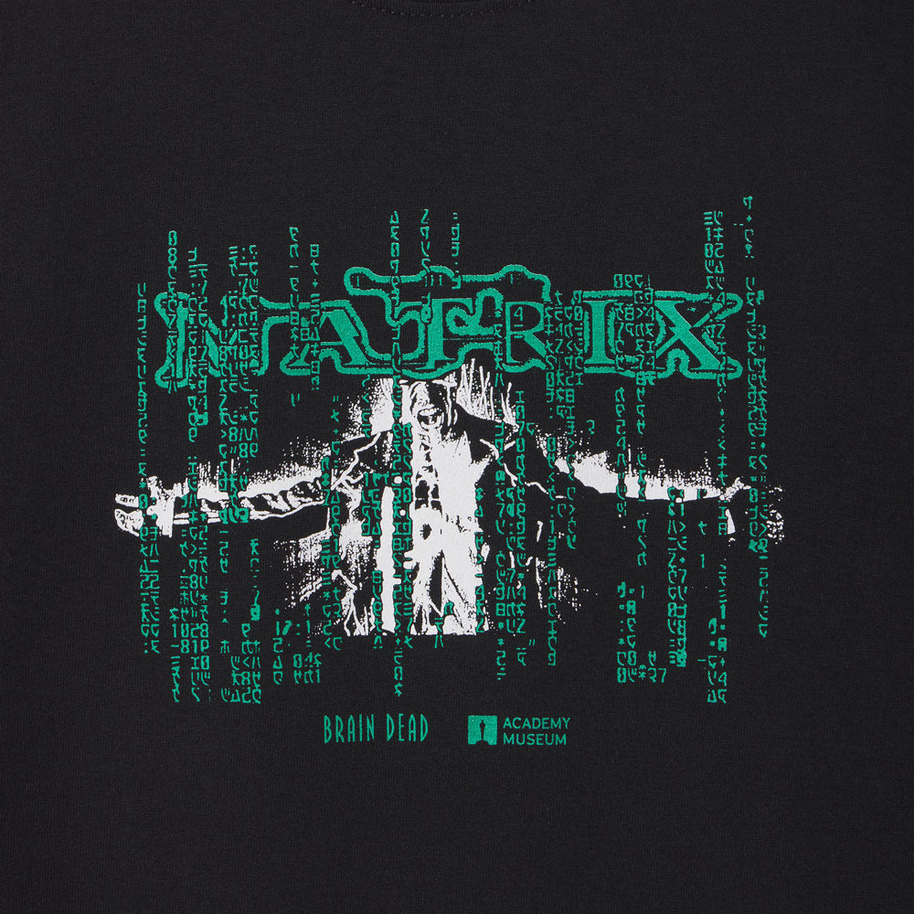 T-shirt with 'The Matrix' design featuring a person in a suit and digital code on a black background. Featuring the logo of Bran Dead and The Academy Museum of the movie The Matrix