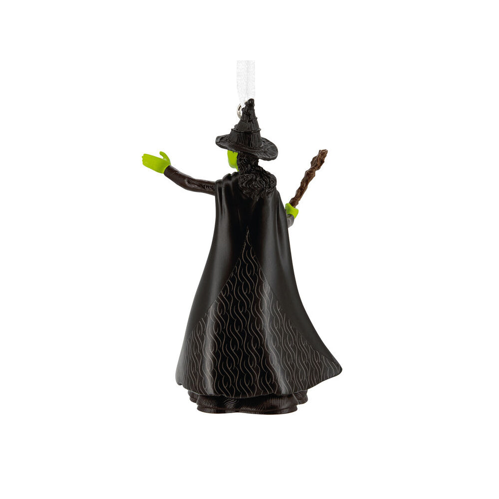Black witch figurine with green hands on a white background