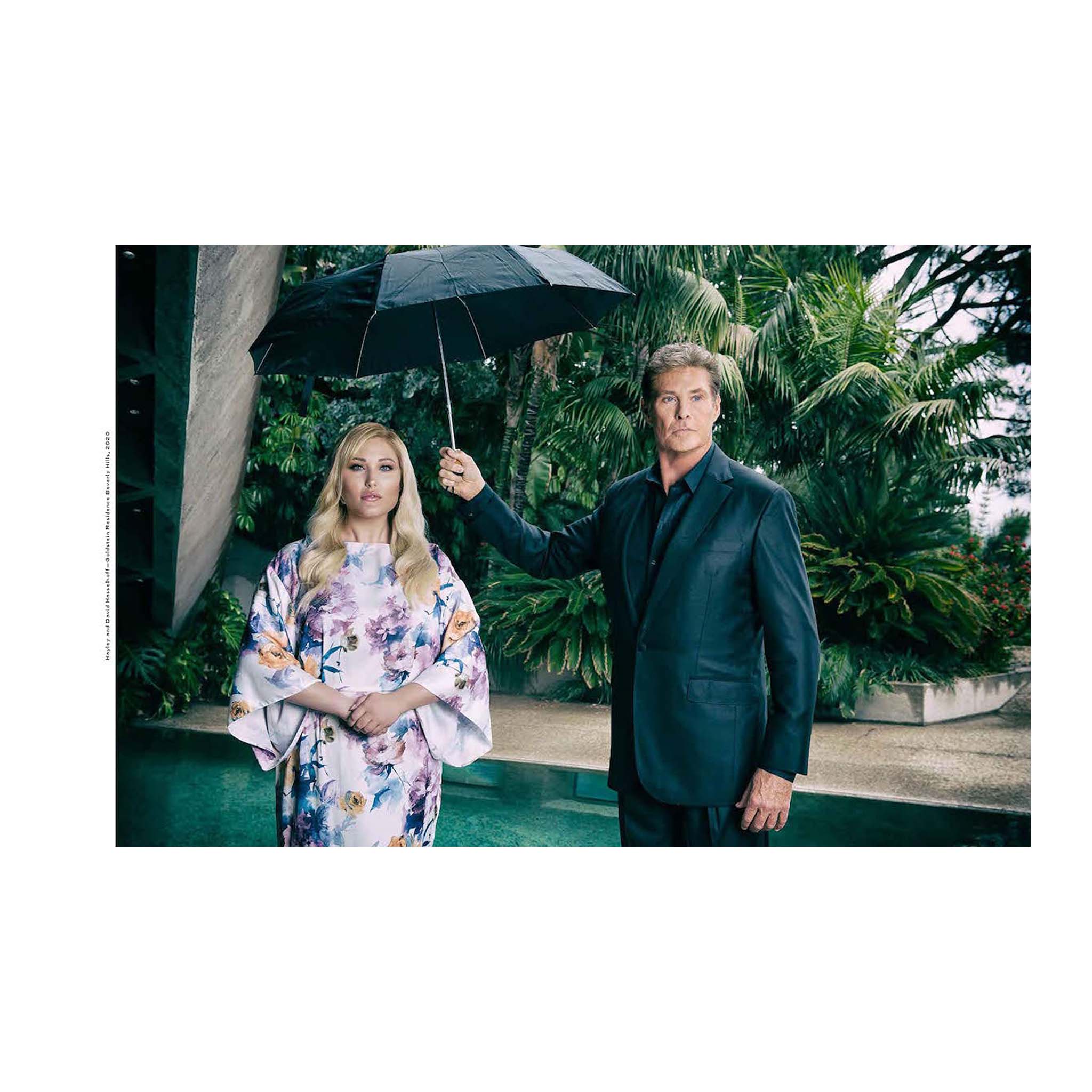David Hasselhoff holding an umbrella over a woman in a floral dress with a garden background