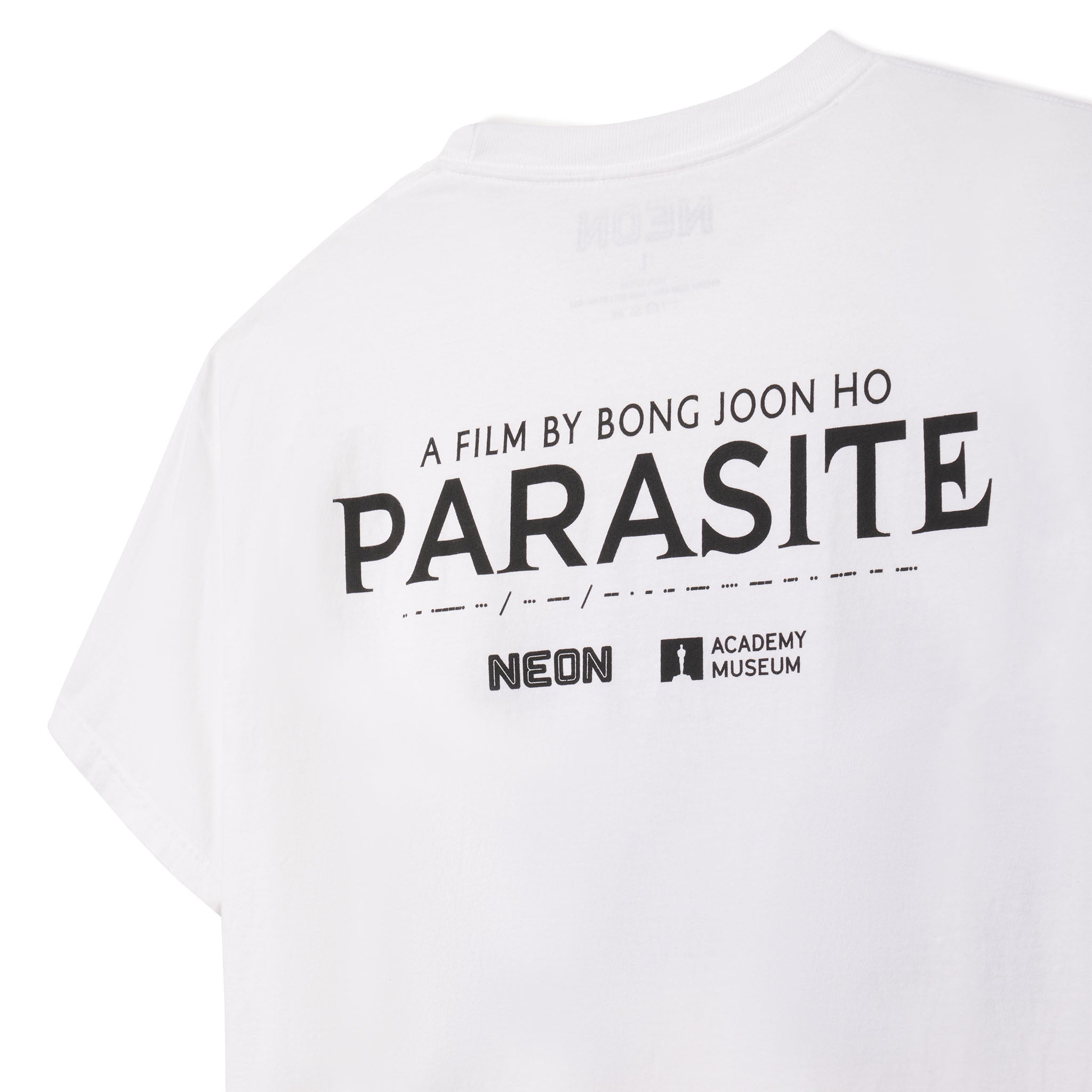 White t-shirt with 'PARASITE' text and logos on a white background closeup image