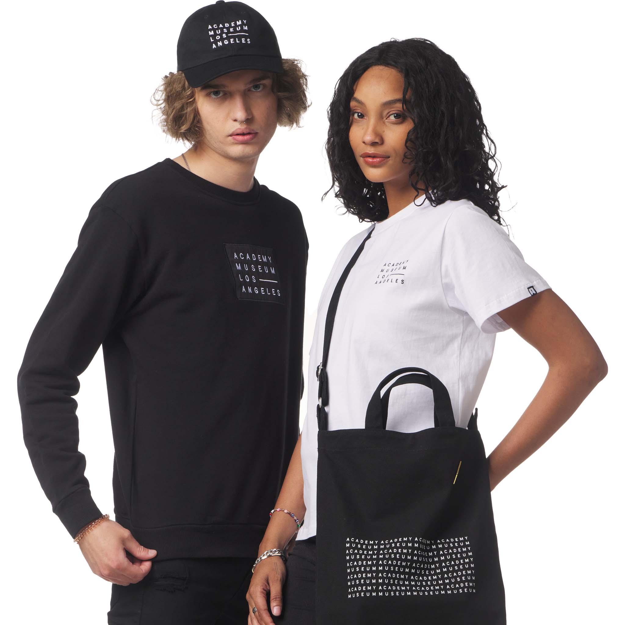 Two people wearing black and white clothing with text, standing against a white background. Academy Museum Logo Merchandise for Men and Women