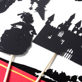 Black paper cutouts of a castle and other shapes on a white background Shadow Puppet Theater for Kids