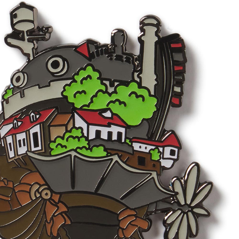 Enamel pin with a design of a steam locomotive, houses, and trees on a white background the castle from the Studio Ghibli film Howls Moving Castle