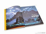 Open book showing a page with a mountain and house illustration, titled 'The Art of My Neighbor Totoro'.