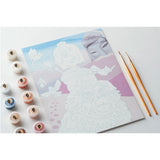 Coloring book with a fairy design, markers, and paintbrushes on a white background