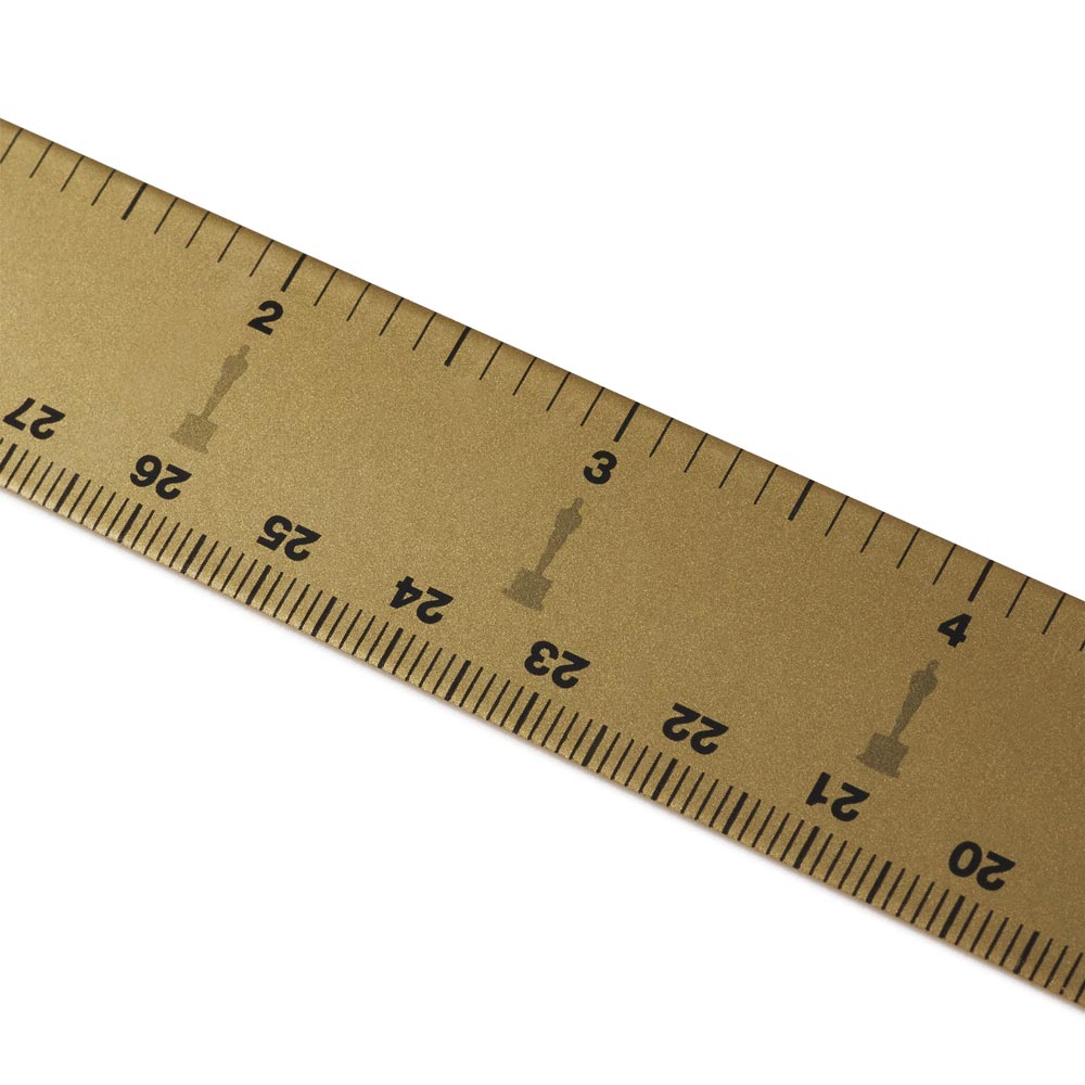 Gold metal ruler with black text on a white background with Oscars Logo
