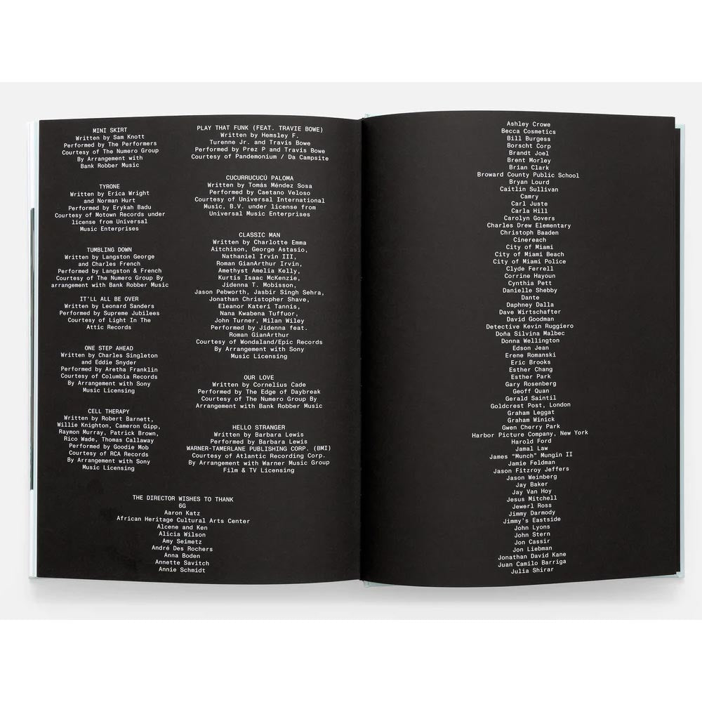 Open book with black pages displaying white text on a white background