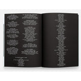 Open book with black pages displaying white text on a white background