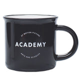 A glossy black ceramic mug with the ACADEMY logo printed on the side against a white background.