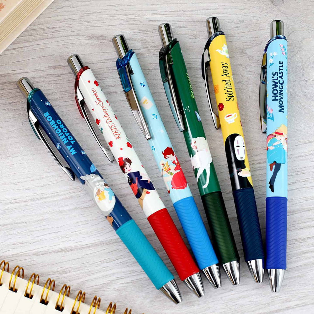 Set of colorful pens with character designs on a light wooden surface