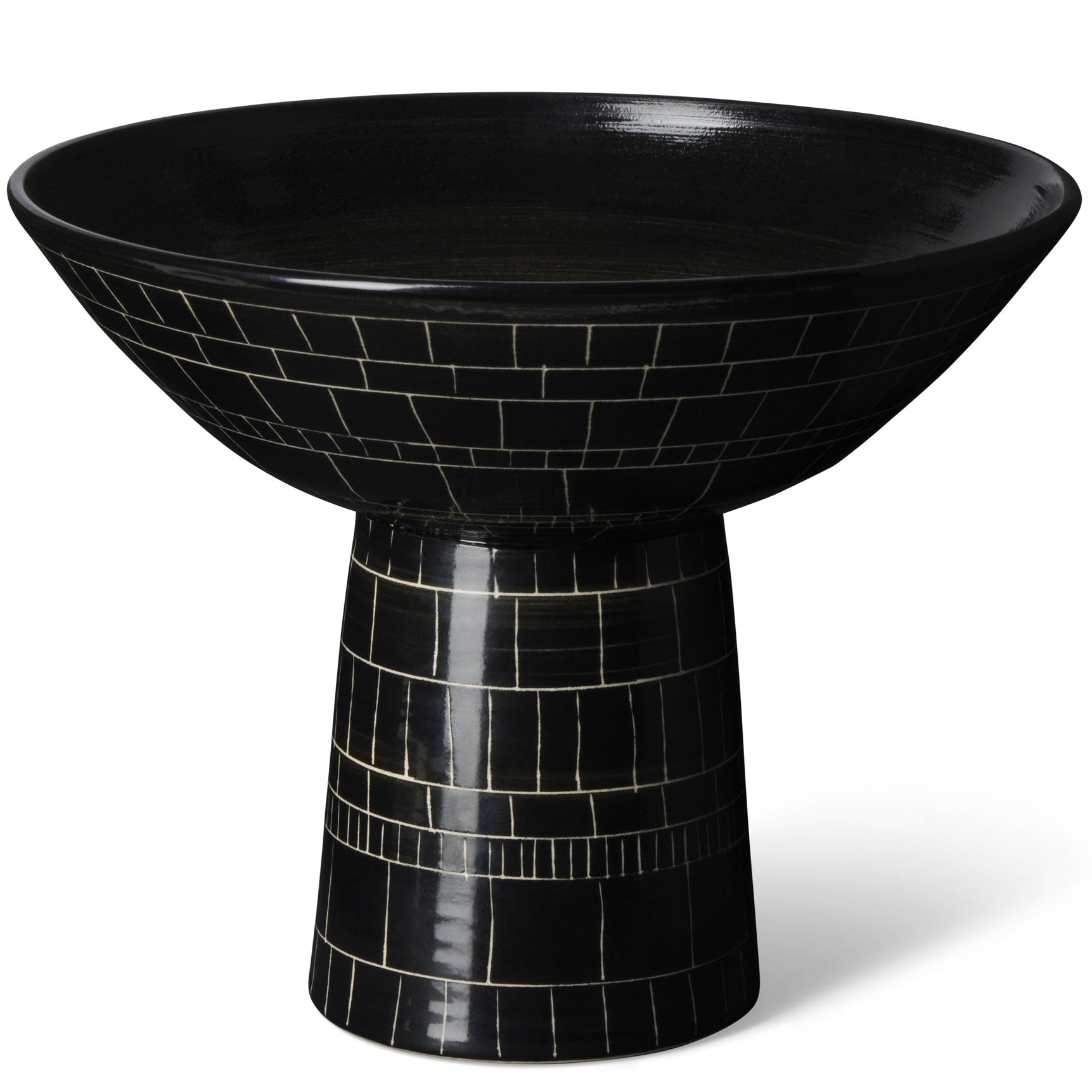 A footed black and white ceramic bowl with geometric patterns.