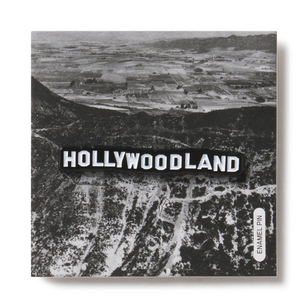 Black and white aerial view of a landscape with 'HOLLYWOODLAND' text overlay.
