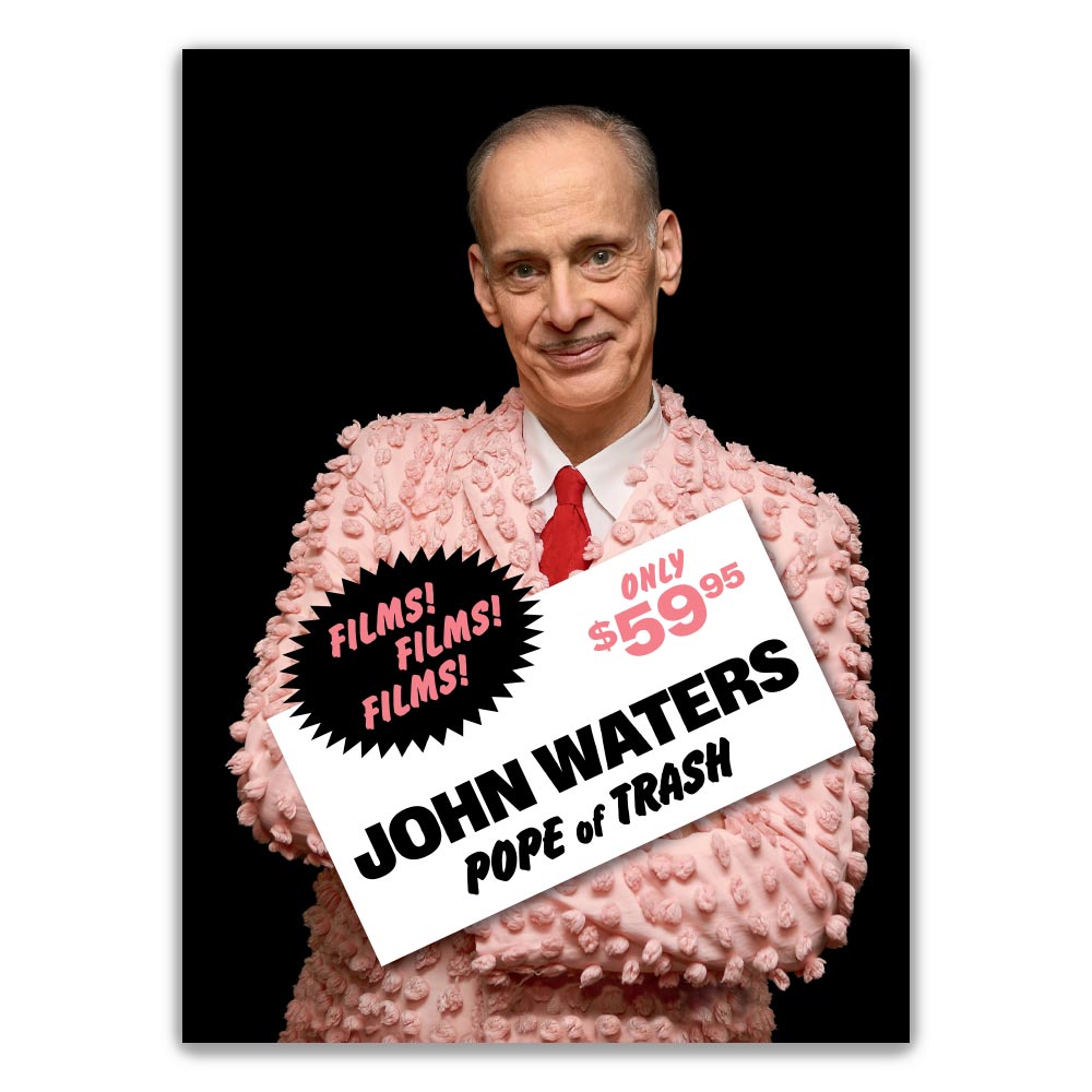 Director John Waters in a pink costume holding a sign that reads 'Films! Films! Films! John Waters - Pope of Trash' with a price tag of $59.95.