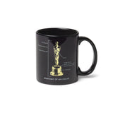 Black ceramic mug with the design of the Oscar statuette and text detailing its anatomy.