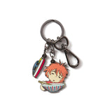 An enamel keychain featuring a character from the movie Ponyo, with a boat charm and a red and blue ribbon.