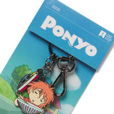 Enamel keychain featuring characters from the movie Ponyo, with a main pendant of Ponyo and a smaller pendant of a boat, attached to a blue card with the movie title.