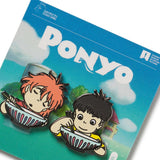 A set of two enamel pins featuring characters from the movie Ponyo, with the main character Ponyo in a red dress and a boy in a yellow shirt, on a card with the movie title.