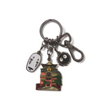 A multicharm keychain featuring raised black nickel metal with pendants in the shapes of characters from Spirited Away, including No Face, Bath House, and Soot Sprites.