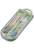 Children's cutlery set with cartoon characters in a green case on a white background. Discover the My Neighbor Totoro Utensil Set (Flower Field) – a charming, officially licensed collection featuring chopsticks, spoon, fork, and a durable case!