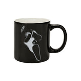 Black mug with a white face design on a white background. Sip your favorite drink in style with our Ghost Face Lives 16 Oz. Ceramic Mug! Perfect for Scream fans, it's microwave and dishwasher safe for easy care.