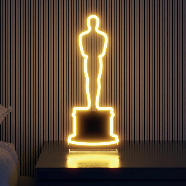 LED Neon Oscar glowing gold in a room on a tabletop Oscar Statue the Academy Awards Show official Oscars Logo Merchandise Collectible Neon Sign Tabletop Size.
