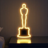 LED Neon Oscar glowing gold in a room on a tabletop Oscar Statue the Academy Awards Show official Oscars Logo Merchandise Collectible Neon Sign Tabletop Size.