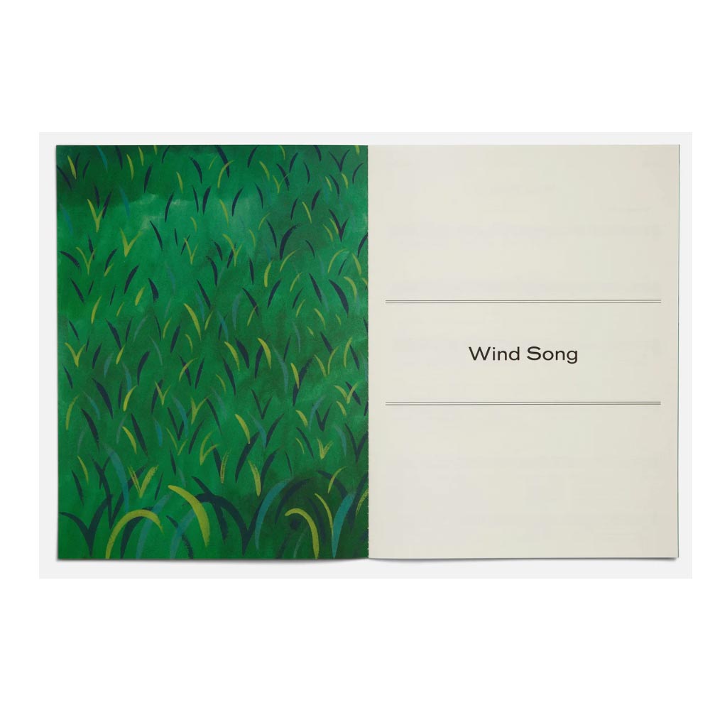 Notebook with green abstract design on one page and 'Wind Song' text on the other, on a white background.