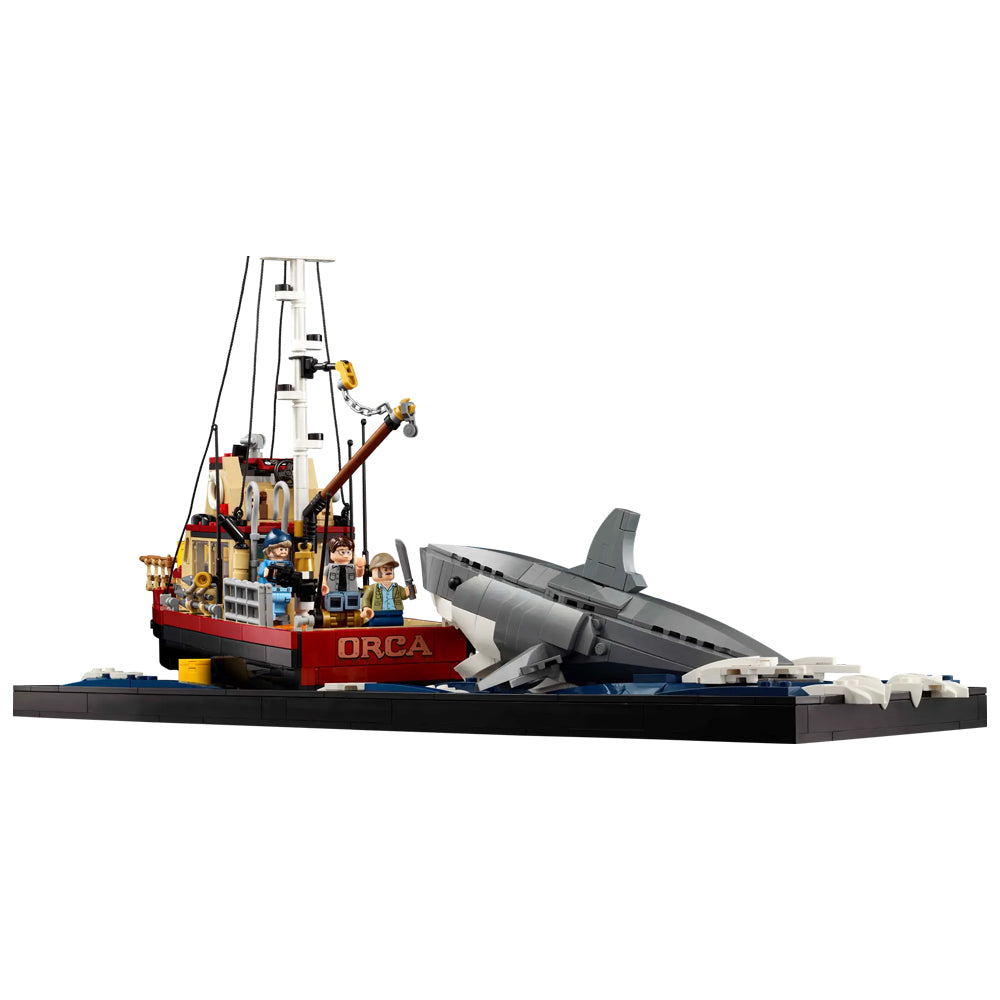 LEGO model of a fishing boat named 'Orca' with a shark nearby on a white background Jaws (1975) 50th Anniversary Lego Set