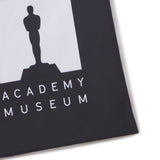 Academy Museum logo with silhouette of the Oscar statuette on a black background