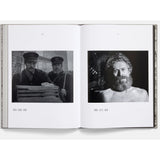 Open book showing black and white photographs of men, with timestamps on each image.