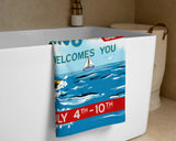 Festive towel with sailboat design and text on a bathtub