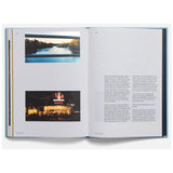 Open book with images of a river and a building at night.