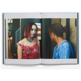 Open book showing two people in a room with a mirror.