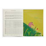 Open book with musical notation on one page and colorful illustration on the other, on a white background.