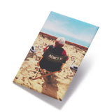 Book titled 'AGNES V.' on a beach with a person sitting on a chair.
