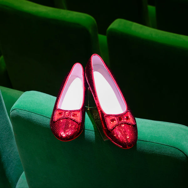 Red shoes on a green theater seat The Ruby Slippers from The Wizard of Oz and the movie Wicked.