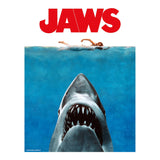 Movie poster for 'Jaws' with a shark emerging from water and two people in the background.