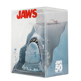 Plush shark toy in a clear packaging with 'JAWS' branding and 50th anniversary text.