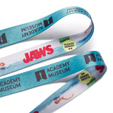 Closeup photo of the lanyard strap with 'Academy Museum' and 'Jaws' branding on a white background