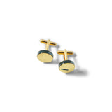 Gold and green round cufflinks on a white background