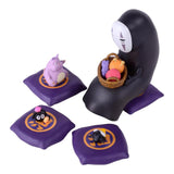 Set of small figurines on purple cushions with a white background No-Face from Spirited Away