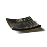 Curved glass plate with geometric pattern on a white background