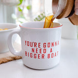 White mug with red text 'You're Gonna Need A Bigger Boat' being filled with coffee.