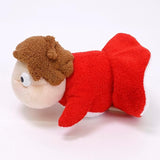 Small plush toy with a red outfit and brown hair on a white background