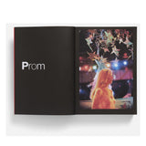 Open book showing a photo of a person at prom with colorful stars in the background. Movie screne from the film Carrie