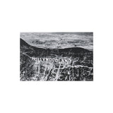 Black and white aerial view of a landscape with 'Hollywoodland' text.
