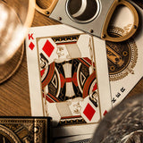 Playing card with a king of diamonds design, scissors, and other objects on a wooden surface. James Bond 007