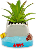 Shark-shaped planter with a plant inside, featuring the 'Jaws' logo.