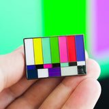 Color test pattern pin held in a hand with a colorful background